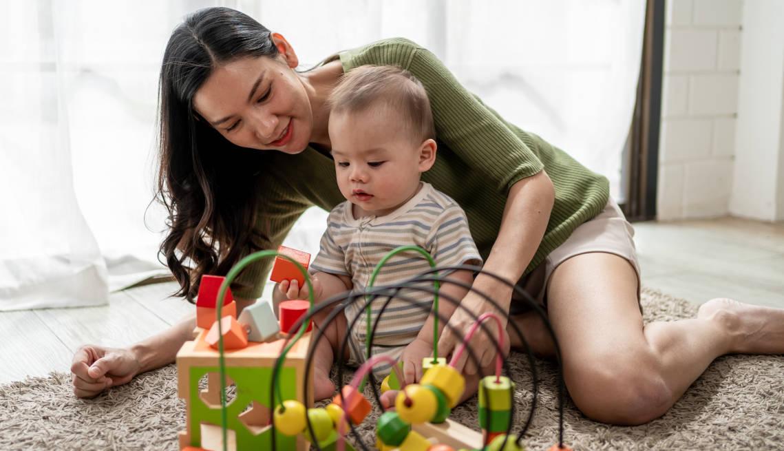 Seorang ibu sedang menemani anaknya bermain